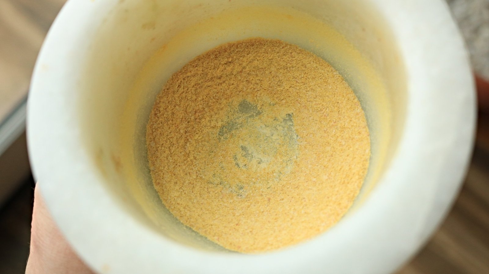 Yellow powder in a mortar without a pestle. 